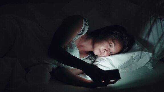 女人晚上在床上用手机