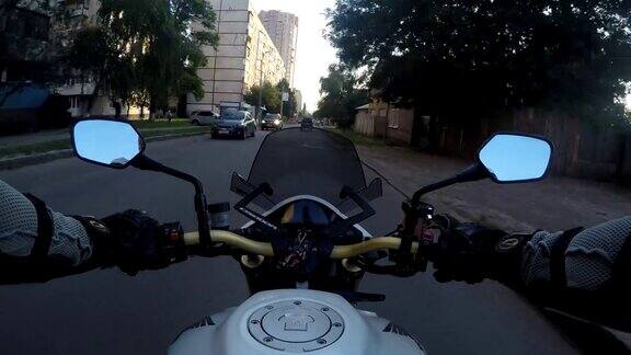 一个骑摩托车的人在日落时高速行驶在城镇道路上的观点摩托车在城市街道上行驶的观点观点关闭