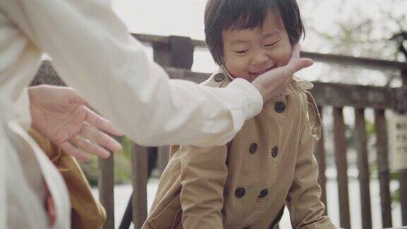 快乐的亚洲小男孩和他的妈妈在公园玩