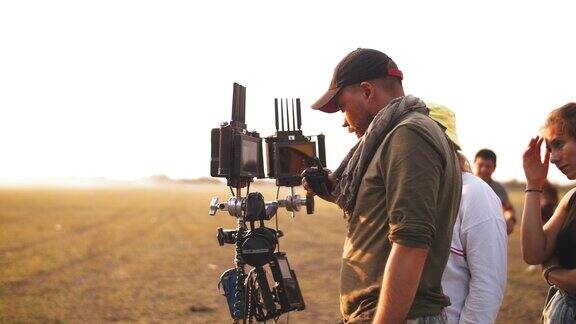 一位身穿反光背心的摄影师正在沙漠中观看拍摄电影拍摄卡车经过电影制作
