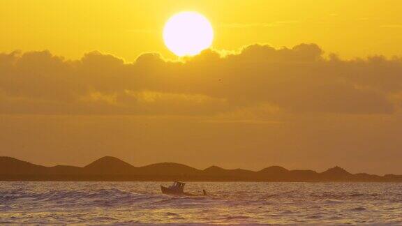 慢镜头:日落时分孤独的小船在平静的海面上缓缓漂流