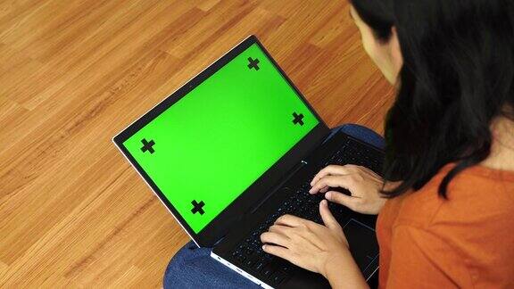 特写女子使用绿色屏幕的笔记本电脑