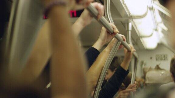 在移动的火车里人们的手抓住栏杆的缓慢动作