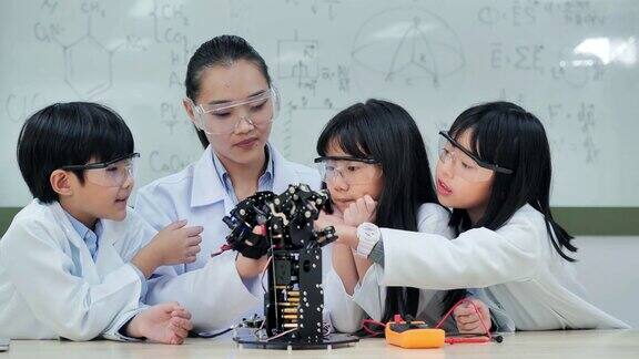 教师和小组的孩子们为学校机器人俱乐部项目制作一个全功能可编程的机器人手臂创意设计师在车间测试机器人原型教育、技术、团队、科学、人本理念教育的主题