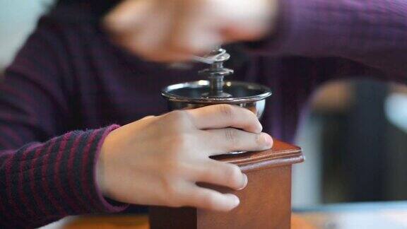 女孩用手工磨咖啡机磨咖啡豆