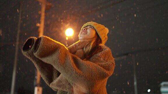 4K亚洲女子在下雪天的步行街上寻找和玩美丽的雪花