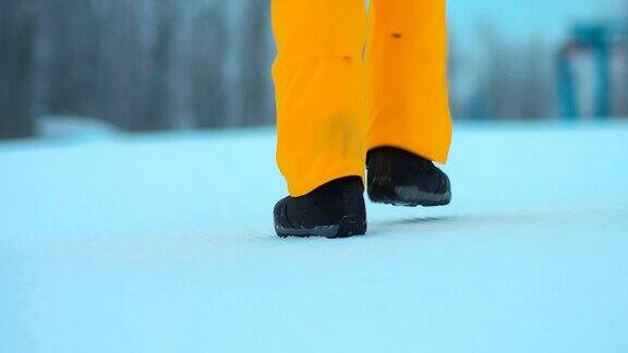 一个人的腿在雪地里行走脚走在雪地上后视图