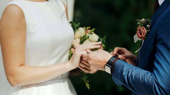 在绿草如茵的背景下新婚夫妇交换戒指