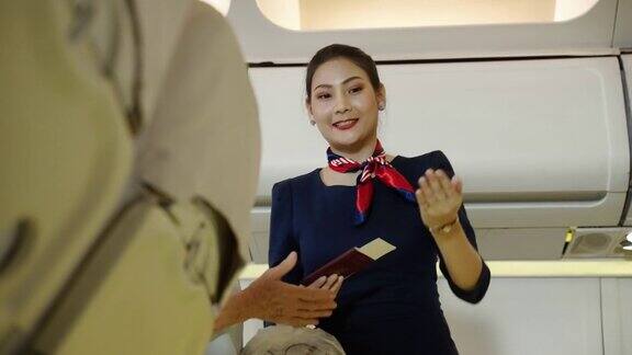 在客机上当乘客将行李放入客舱时空乘人员欢迎乘客