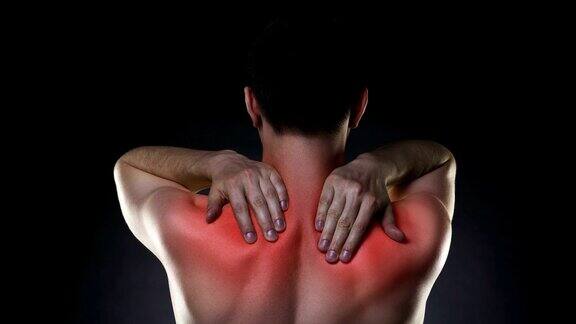 颈部疼痛背部疼痛的男人在黑色背景