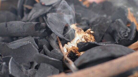 在木炭上烧纸以供烧烤纸在闷烧的煤上燃烧