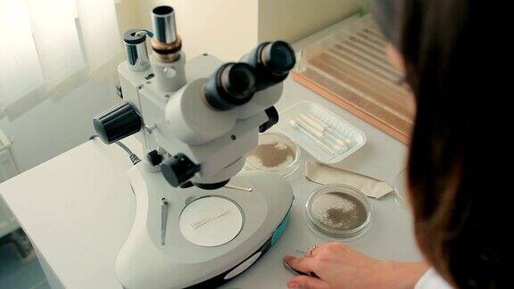 一个女人在显微镜下看一张纸条