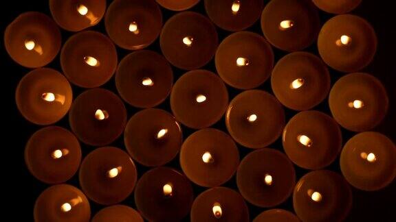许多燃烧着的圆圆的小蜡烛在黑暗中燃烧
