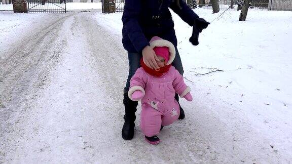 可爱的小女孩在冬天的雪地上快步走着FullHD