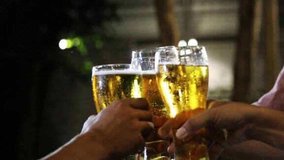 一群亚洲朋友在聚会上喝含酒精的啤酒年轻人在酒吧里举杯互饮