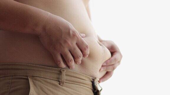 亚洲年轻人在家里摸着自己的大肚子超重胖肚子饮食生活方式、胃肌、脂肪健康理念