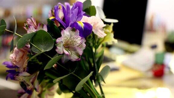 在花店桌上的花瓶里有一束鸢尾花