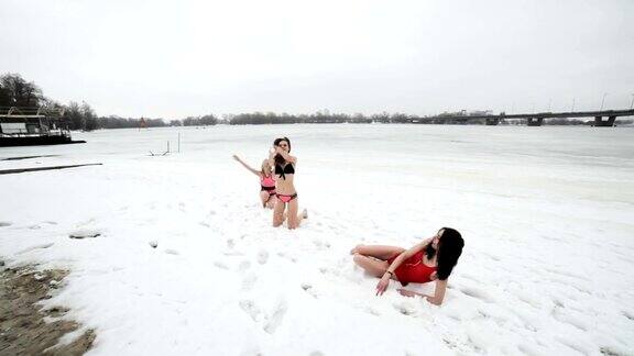 穿着泳衣的妇女在雪地里嬉戏