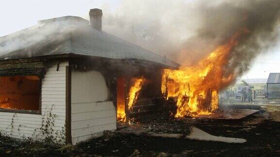 着火的房子在慢动作中燃烧背景是消防员
