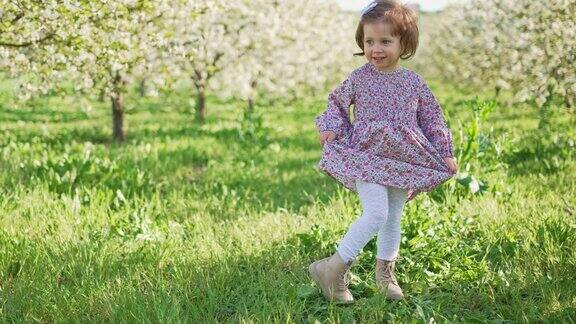 在春天的花园里一个穿着紫罗兰色裙子的漂亮女孩