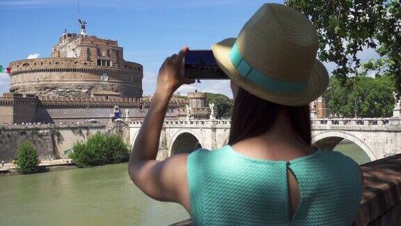 一名女子在圣天使城堡附近用手机拍照女游客在著名的地方拍照