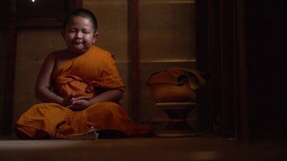东南亚泰国小和尚在寺院内打坐传授佛法年轻的沙弥和尚在寺院里学习