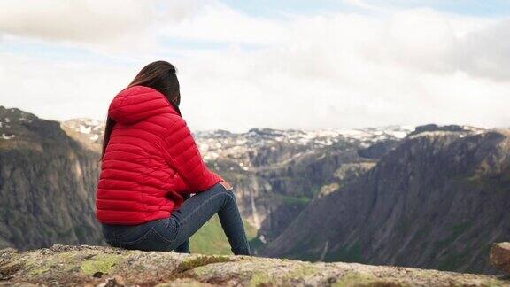 女性徒步旅行者坐在山顶俯瞰大自然