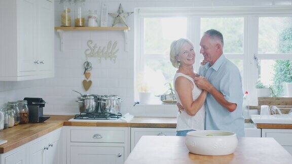 退休的浪漫老年情侣一起在家厨房跳舞