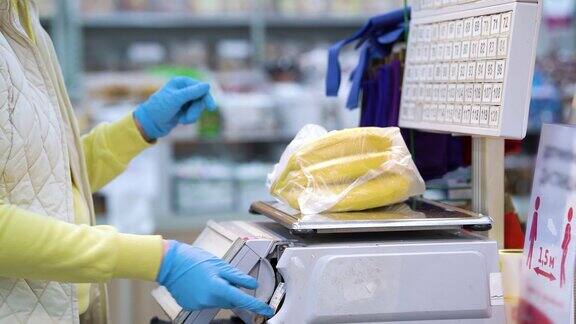 超市里戴着一次性手套称量香蕉的妇女