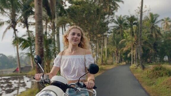 年轻女子骑摩托车在热带岛屿公路旅行享受摩托车旅行度假4k