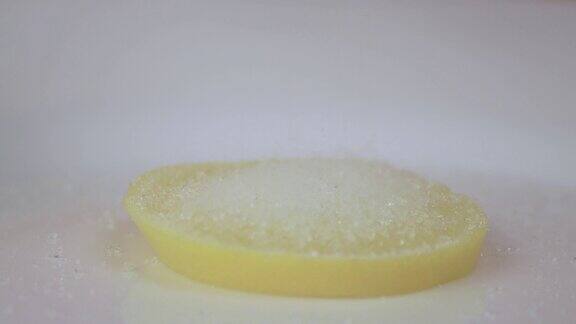 盘子上的柠檬上面慢慢撒上砂糖