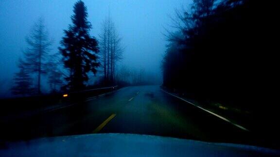 夜晚汽车在雾蒙蒙的山上行驶