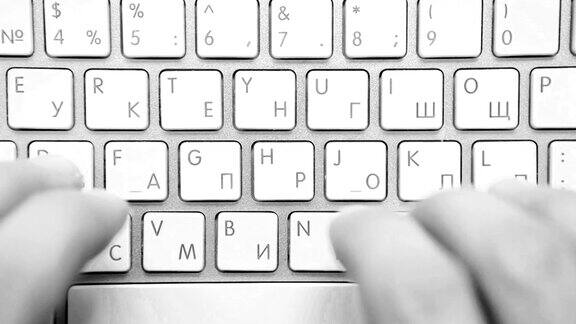 一个人在双语键盘上打字的黑白画面