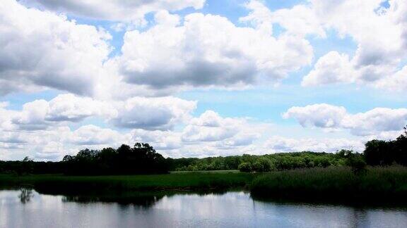 阳光明媚的日子湖边绿树成荫天空乌云密布