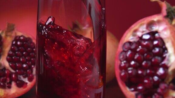 特写的果汁流入一个罐子在红色背景的石榴一半
