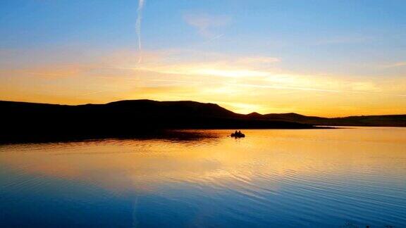 渔人的船在晨曦的湖与山