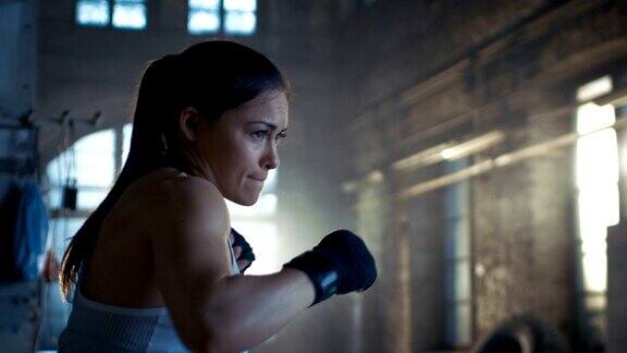 美丽的运动员女子拳击空气与她的拳头作为她的密集交叉健身健身房训练的一部分