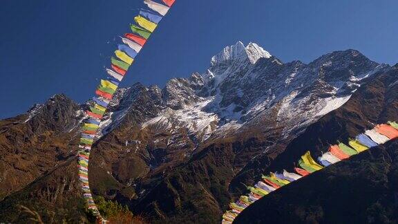 尼泊尔绘有佛经的彩旗在强风中飘扬背景是白雪覆盖的喜马拉雅山脉UHD
