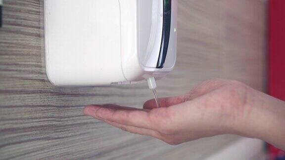 妇女使用自动洗手液来预防感染