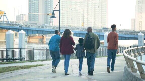 一家人沿着城市海滨散步