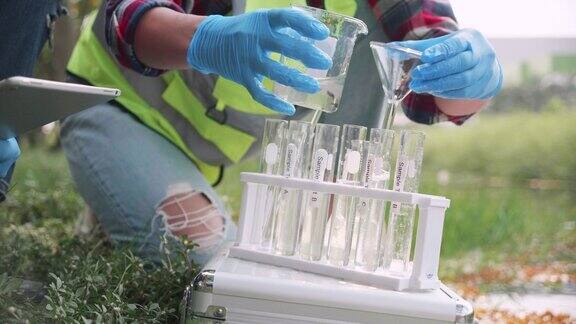 女科学家在试管中收集工厂废水样本的特写