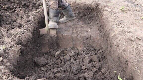 人挖了一个深坑用铁锹挖坑