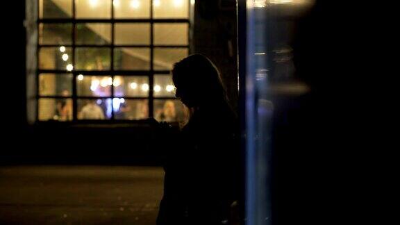 孤独的女孩站在夜总会附近的小巷里叫出租车夜生活