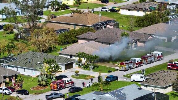 火灾房屋的鸟瞰图消防员在短路导致火花点燃飓风伊恩风损坏的木质屋顶后灭火佛罗里达郊区的家庭灾难