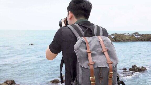 年轻的亚洲男子摄影师拍摄的热带岛屿海滩海景背景暑假和度假旅游