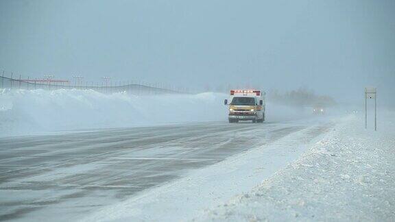 救护车行驶在冬季暴风雪的高速公路上