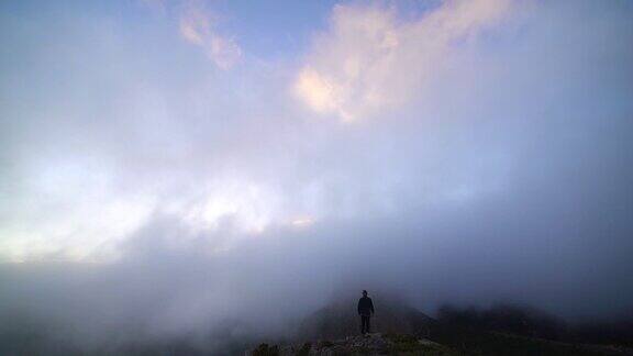 孤独的人站在悬崖边看雾