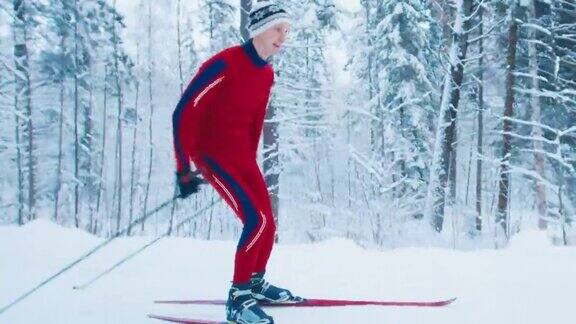 越野滑雪穿着红色滑雪服的年轻男子在冬季森林滑雪