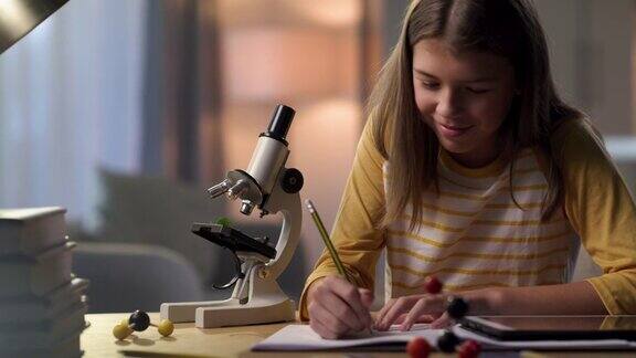 一个小女孩独自坐在家里用显微镜做作业的4k视频片段