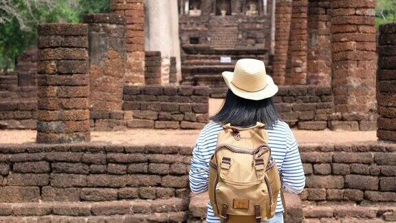 亚洲女游客行走在古老的塔寺庙泰国建筑在素可泰泰国女性旅行者在休闲泰国服装风格访问城市概念